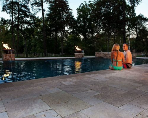 pool view with couple sitting on edge